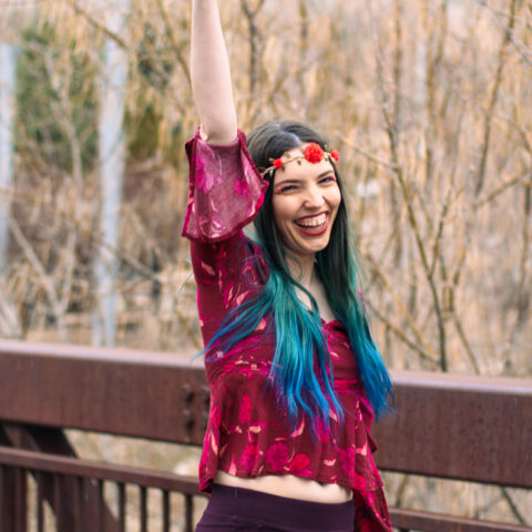 Woman dressed in disco and groovy clothes cheers while smiling at Zoo Brew cheers at Utah's Hogle Zoo