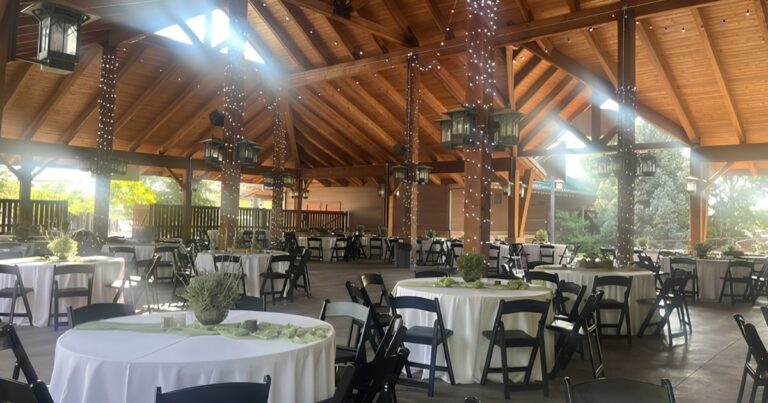 Tables, twinkle lights, and decor are set up at a wedding reception venue in Salt Lake City Utah’s Hogle Zoo.