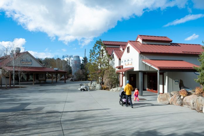 A man pushes a stroller and walks next to a child at an after-hours corporate buyout event where they’re able to view exhibits without the crowds.